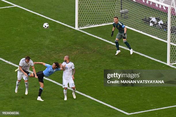 Uruguay's forward Edinson Cavani battles with Russia's forward Artem Dzyuba and Russia's defender Fyodor Kudryashov as Russia's goalkeeper Igor...