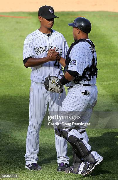 Relief pitcher Esmil Rogers and catcher Miguel Olivo of the Colorado Rockies celebrate after the final out against the San Diego Padres during MLB...