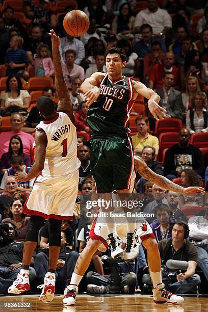 Carlos Delfino of the Milwaukee Bucks passes against Dorell Wright of the Miami Heat during the game at American Airlines Arena on February 27, 2010...