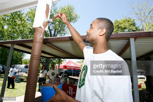 Hilton Armstrong of the Houston Rockets helps paint Emily Elmore's house during NBA Green Week on April 8, 2010 in Houston, Texas. NOTE TO USER: User...