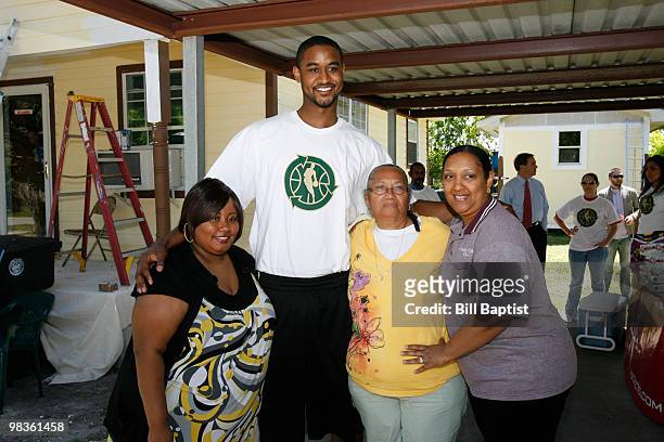 Hilton Armstrong of the Houston Rockets stands with Emily Elmore and her daughters before painting her house during NBA Green Week on April 8, 2010...