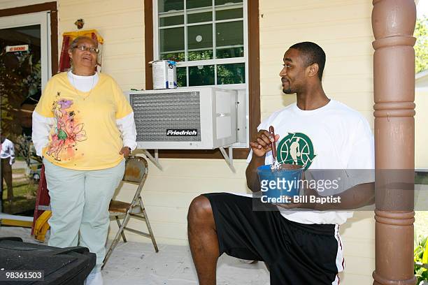 Hilton Armstrong of the Houston Rockets talks to Emily Elmore as he helps paint her house during NBA Green Week on April 8, 2010 in Houston, Texas....