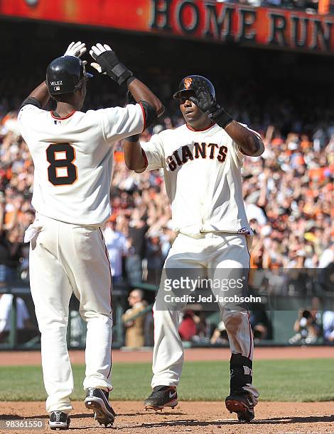 Edgar Renteria of the San Francisco Giants is congratulated by Eugenio Velez after hitting a two run home run in the ninth inning to tie the game at...