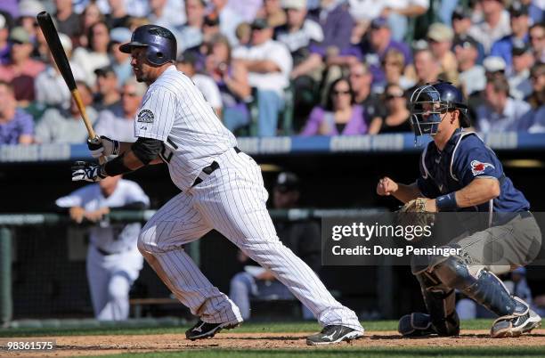 Miguel Olivo of the Colorado Rockies follows through on an RBI single in the eighth inning that scored Troy Tulowitzki off of Sean Gallagher of the...