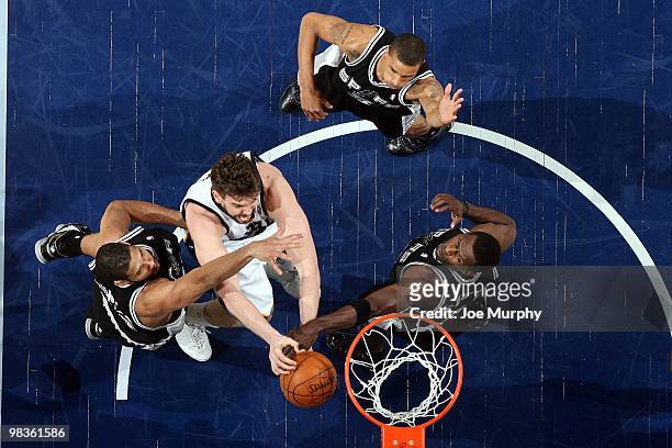 Marc Gasol of the Memphis Grizzlies goes up for a shot against Tim Duncan, George Hill and Antonio McDyess of the San Antonio Spurs during the game...