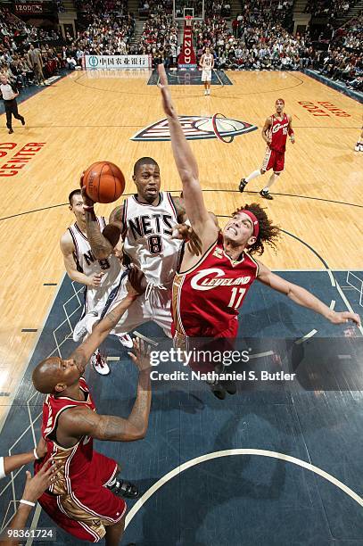 Terrence Williams of the New Jersey Nets goes up for a shot against Jawad Williams and Anderson Varejao of the Cleveland Cavaliers during the game at...
