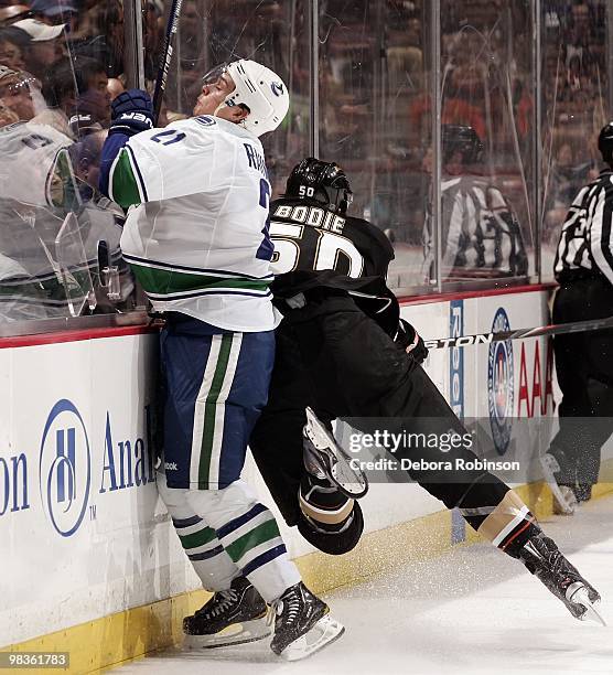 Troy Bodie of the Anaheim Ducks checks Mason Raymond of the Vancouver Canucks into the boards during the game on April 2, 2010 at Honda Center in...