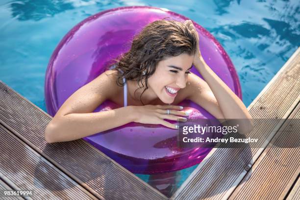 model in rubber ring in swimming pool - rubber ring stock-fotos und bilder