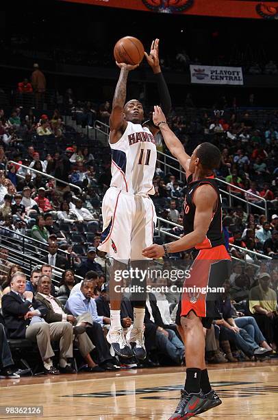 Jamal Crawford of the Atlanta Hawks shoots against DeMar DeRozan of the Toronto Raptors on April 9, 2010 at Philips Arena in Atlanta, Georgia. NOTE...