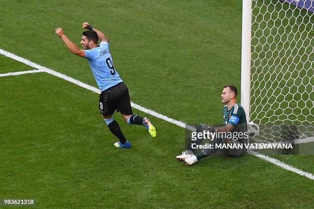 Uruguay's forward Luis Suarez celebrates and Russia's goalkeeper Igor Akinfeev reacts after Uruguay's second goal scored by Uruguay's defender Diego...