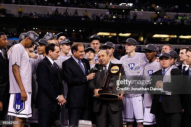 Head coach Mike Krzyzewski of the Duke Blue Devils receives the trophy as his players celebrate after they won 61-59 against the Butler Bulldogs...