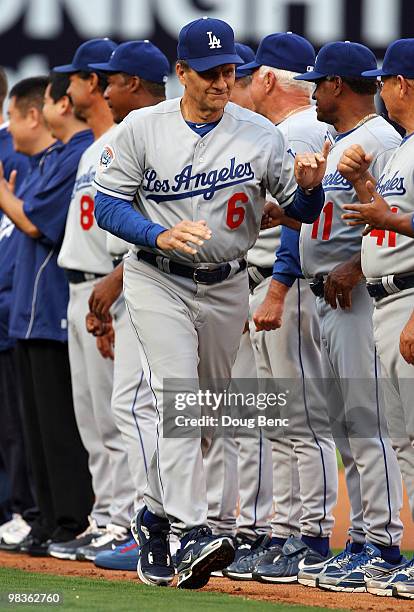 Manager Joe Torre of the Los Angeles Dodgers is greeted by his coaches and players before taking on the Florida Marlins during the Marlins home...