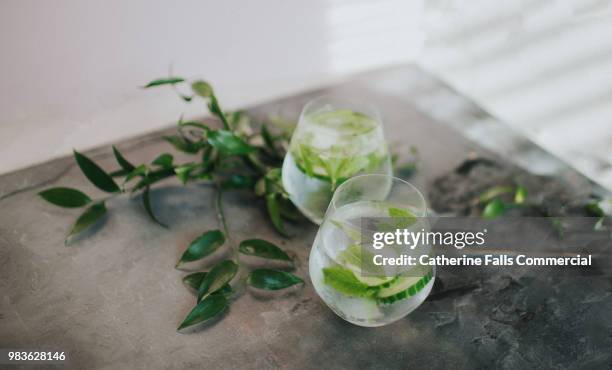 refreshing glass of water or gin and tonic - cucumber stockfoto's en -beelden