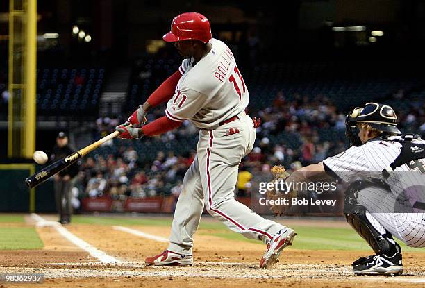 Jimmy Rollins of the Philadelphia Phillies singles to right field in the second inning as catcher J.R. Towles looks on against the Houston Astros at...