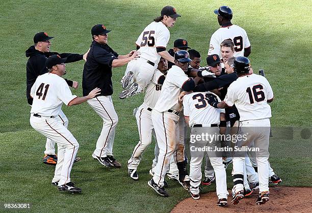 Aaron Rowand of the San Francisco Giants is mobbed by teammates after driving in the winning run during the thirteenth inning against the Atlanta...