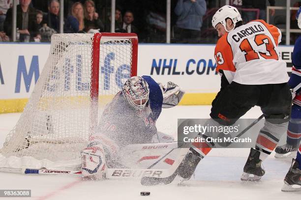 Henrik Lundqvist of the New York Rangers makes a save under pressure from Dan Carcillo of the Philadelphia Flyers during their game on April 9, 2010...