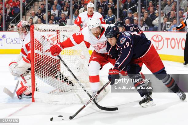 Umberger of the Columbus Blue Jackets and Niklas Kronwall of the Detroit Red Wings battle for a loose puck behind the net of goaltender Jimmy Howard...