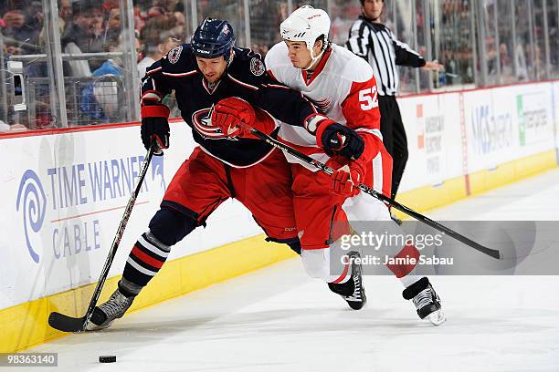 Marc Methot of the Columbus Blue Jackets and Jonathan Ericsson of the Detroit Red Wings chase after a loose puck during the third period on April 9,...