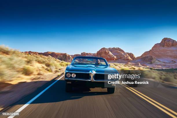 man driving vintage car through desert - joshua rush stock pictures, royalty-free photos & images