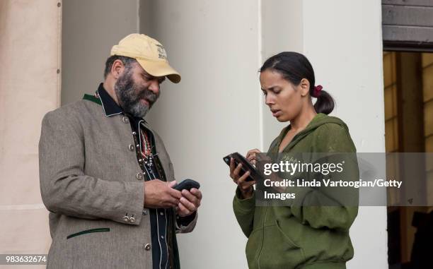 American folk and country blues musicians Otis Taylor and Rhiannon Giddens exchange contact information between sets on the stage of the Petrillo...