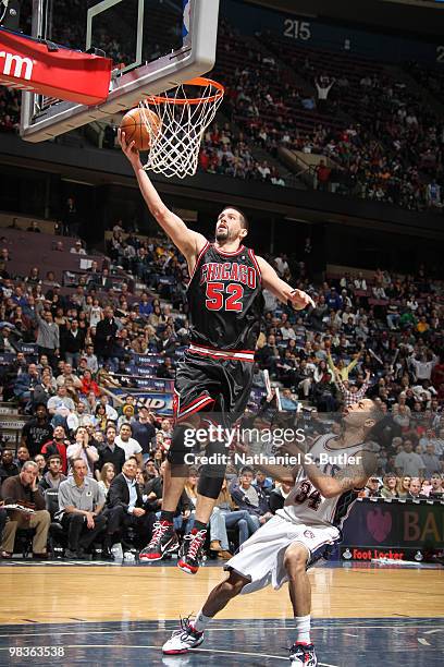 Brad Miller of the Chicago Bulls shoots against Devin Harris of the New Jersey Nets on April 9, 2010 at the IZOD Center in East Rutherford, New...