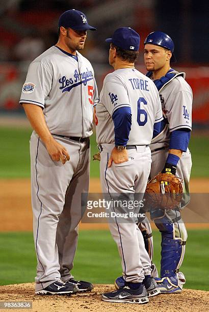 Relief pitcher Jonathan Broxton of the Los Angeles Dodgers talks with manager Joe Torre and catcher Russell Martin before pitching in the ninth...