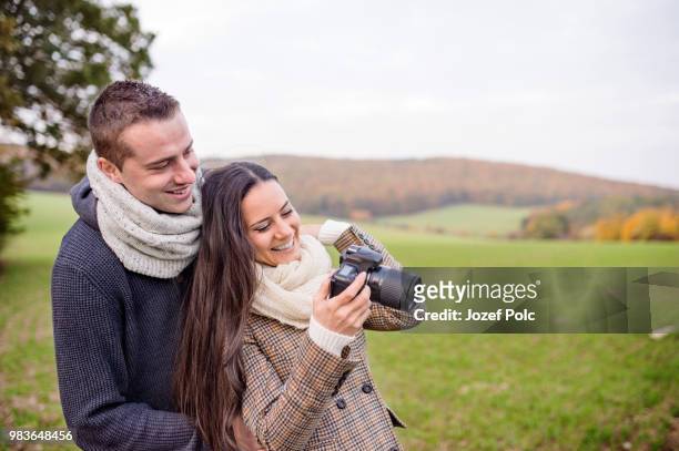 beautiful young couple with camera taking pictures. autumn natur - natuur stock pictures, royalty-free photos & images