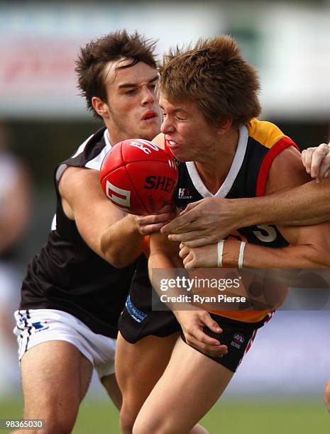 Lachlan Wallace of the Stingrays is tackled by Keenan George of the Rebels during the round three TAC Cup match between the Dandenong Stingrays and...