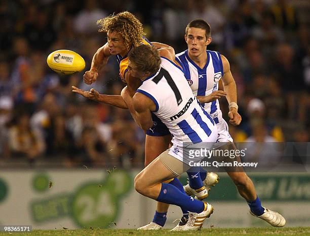 Matt Priddis of the Eagles handballs whilst being tackled by Jack Ziebell of the Kangaroos during the round three AFL match between the North...