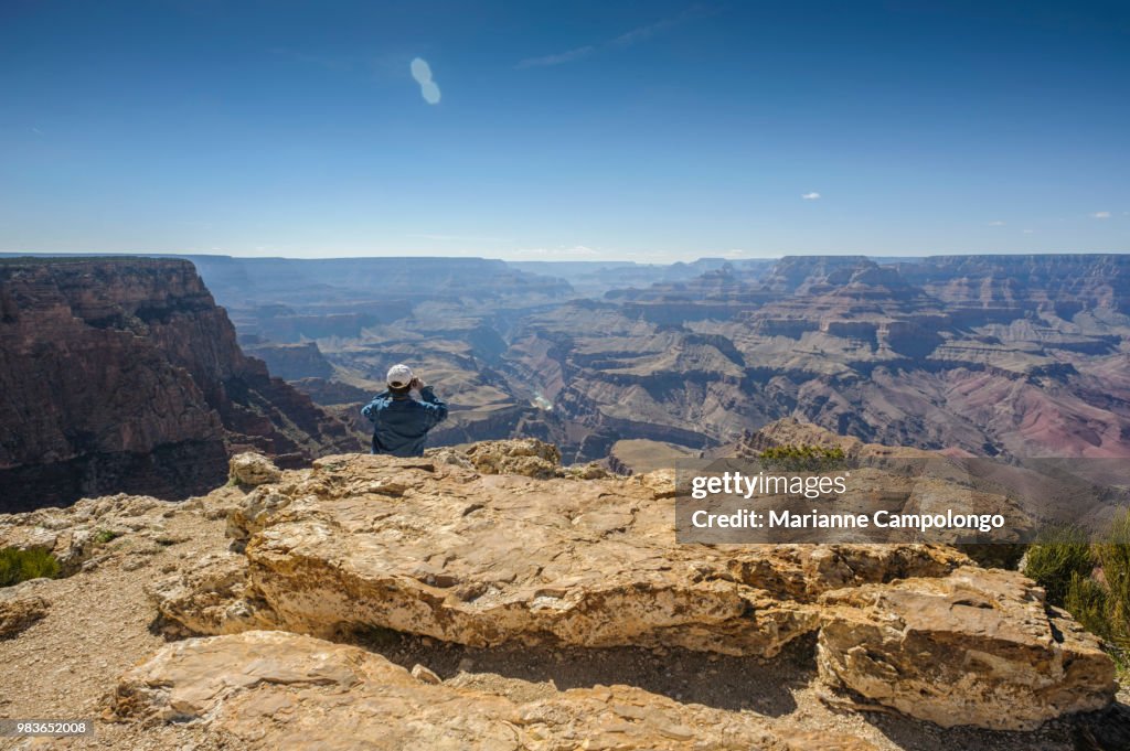 Man takes photo at the edge of Grand Canyon