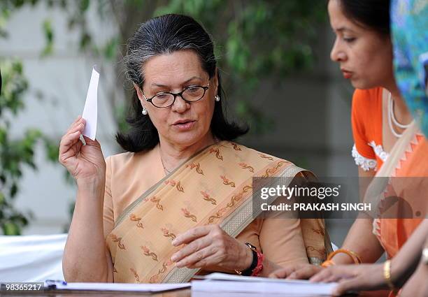 Congress Party President and United Progressive Alliance Chairperson Sonia Gandhi is assisted by Indian census officials to record details of her and...