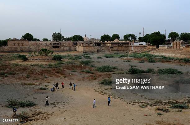 Indian children play cricket in the dry bed of Ahmad Sar lake of Sarkhej Roza, an ancient monument built in the 15th century, situated south-west of...