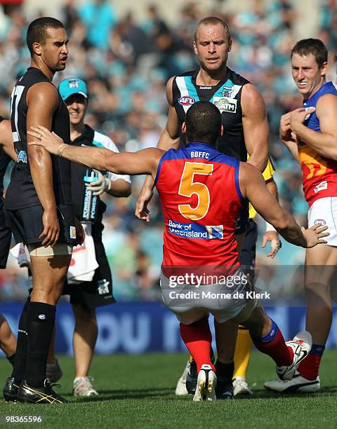 Alipate Carlile of the Power watches as Chad Cornes of the Power pushes over Brendan Fevola of The Lions during the round three AFL match between...