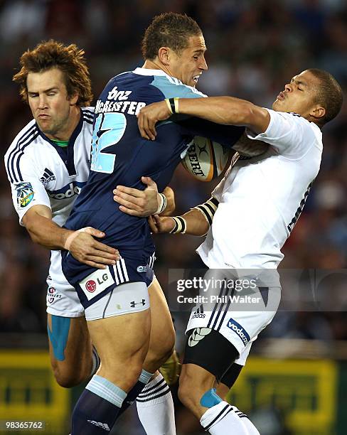 Luke McAlister of the Blues is tackled by Peter Grant and Juan de Jongh of the Stomers during the round nine Super 14 match between the Blues and the...