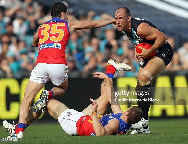 Warren Tredrea of the Power tries to get away from Michael Rischitelli of the Lions during the round three AFL match between Port Adelaide Power and...