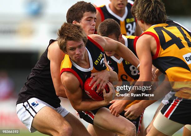 Callum Currie of the Rebels tackles Lachlan Wallace of the Stingrays during the round three TAC Cup match between the Dandenong Stingrays and the...