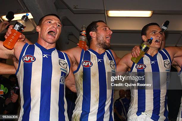 Brent Harvey, Ben Speight and Scott Thompson of the Kangaroos sing the song in the rooms after winning the round three AFL match between the North...