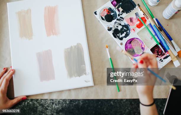 female artist painting at a work station - back brush stock pictures, royalty-free photos & images