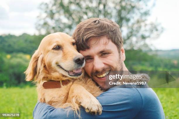 guy and his dog, golden retriever, nature - golden guys stock pictures, royalty-free photos & images