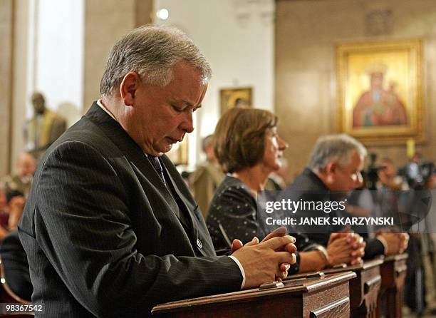 Polish Prime Minister Jaroslaw Kaczynski, President Lech Kaczynski and his wife Maria pray during a mass in Warsaw's church 23 July 2007 in honour of...