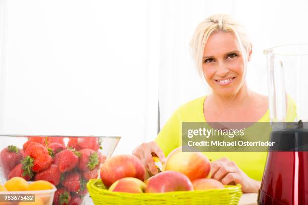 mature woman preparing a smoothie - wax fruit stock pictures, royalty-free photos & images