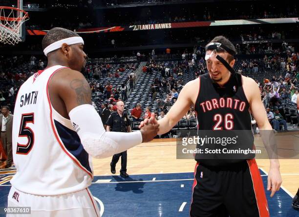 Josh Smith of the Atlanta Hawks is congratulated by Hedo Turkoglu of the Toronto Raptors after the game on April 9, 2010 at Philips Arena in Atlanta,...