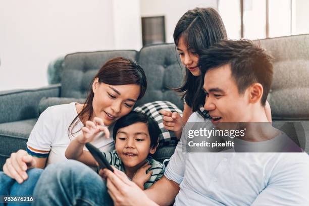 young family texting at home - malaysia family stock pictures, royalty-free photos & images