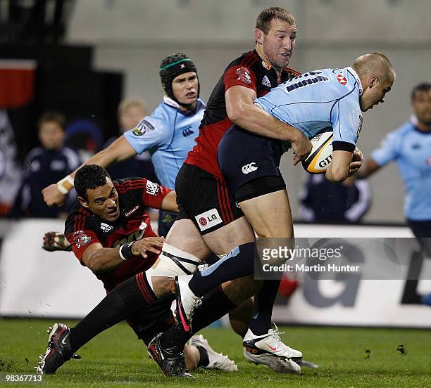 Drew Mitchell of the Waratahs is tackled by Chris Jack and Kahn Fotuali'i of the Crusaders during the round nine Super 14 match between the Crusaders...