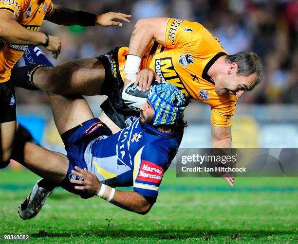 Johnathan Thurston of the Cowboys is tackled by Gareth Ellis of the Tigers during the round five NRL match between the North Queensland Cowboys and...