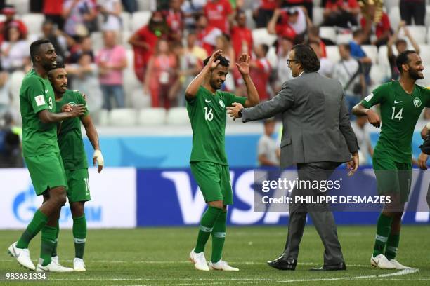 Saudi Arabia's Argentine-born Spanish coach Juan Antonio Pizzi congratulates midfielder Hussain Al Moqahwi after they won the Russia 2018 World Cup...