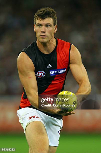 David Hille of the Bombers handballs during the round three AFL match between the Carlton Blues and the Essendon Bombers at the Melbourne Cricket...