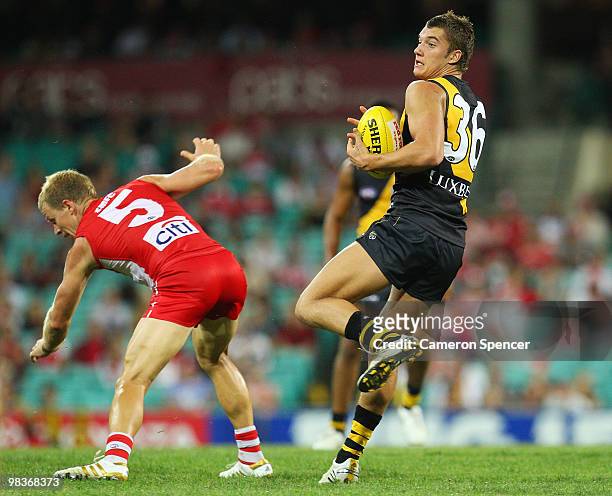 Dustin Martin of the Tigers avoids the tackle of Ryan O'Keefe of the Swans during the round three AFL match between the Sydney Swans and the Richmond...