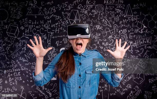 beautiful woman wearing virtual reality goggles against big blac - office game stock pictures, royalty-free photos & images