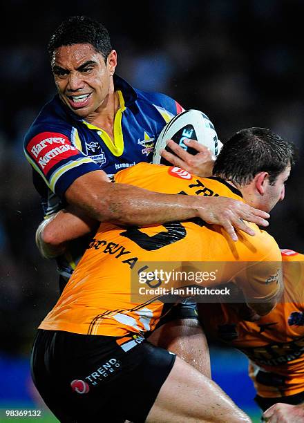 Willie Tonga of the Cowboys is tackled by Mitch Brown of the Tigers during the round five NRL match between the North Queensland Cowboys and the West...